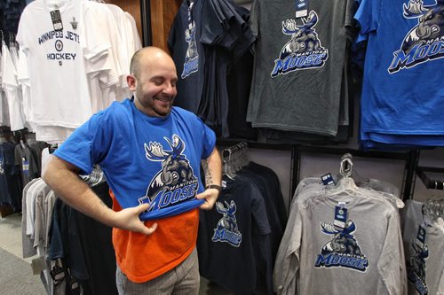Justin Chaput tries on one of the new Manitoba Moose t-shirts at the Jets Gear Store at the MTS Centre Monday. The Winnipeg Jets affiliate AHL team is moving back to Winnipeg next season with a familiar new name and logo.  150504 May 4, 2015 Mike Deal / Winnipeg Free Press