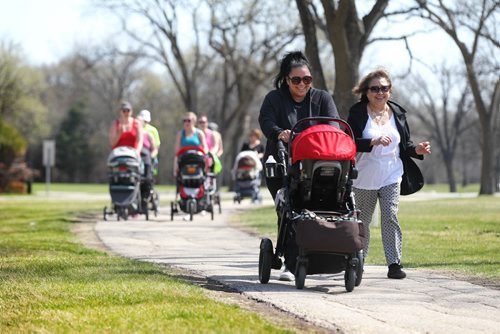 Abbey David laughs as she walks with her mother-in-law Lita David along a walking path in Assiniboine Park while pushing her two children, Lauren and Marcus, in the stroller during thier stroller training workout. 
49.8 Certified post and pre natal trainer, Cindy Miller (front of crowd, red hair with pony tail) hosts workout sessions for new moms at Assiniboine park recently.  Classes last 45 - 50 minutes - moms walk vigorously for 5 minutes with their strollers, then pause to do lunges, step-ups, etc. for 5 minutes, then walk again, stop again until meeting back at the starting point, the pavilion, to do a cool down stretch.    See story Dave Sanderson's story. May 01, 2015 Ruth Bonneville / Winnipeg Free Press