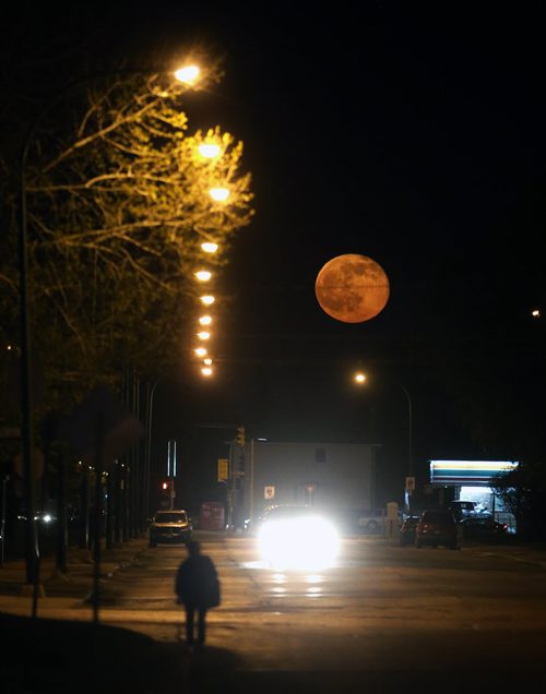 A nearly full moon rises above Mountain Avenue, Monday, May 4, 2015. (TREVOR HAGAN/WINNIPEG FREE PRESS)