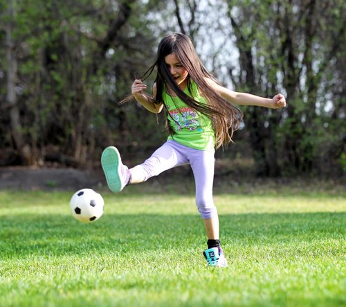 Six-year-old Bela Ulloa-Baet loves learning to kick a soccer ball around as she plays with her mom at Assiniboine Park Tuesday evening.    May 05, 2015 Ruth Bonneville / Winnipeg Free Press
