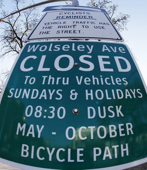 May 5, 2015 - 150505  -  Cars, pedestrians, cyclists and pedestrians pass signage on Wolseley Avenue indicating Sunday and holiday street closure Tuesday, May 5, 2015. City police are planning to increase enforcement along this type of route John Woods / Winnipeg Free Press
