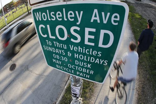 May 5, 2015 - 150505  -  Cars, pedestrians, cyclists and pedestrians pass signage on Wolseley Avenue indicating Sunday and holiday street closure Tuesday, May 5, 2015. City police are planning to increase enforcement along this type of route John Woods / Winnipeg Free Press