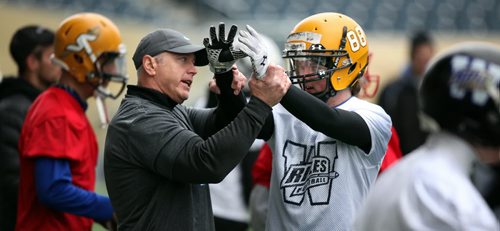 Up close and personal, Matt Dunigan sets the record straight with a receiver Thursday evening at the Winnipeg Rifles spring camp - assisting with quarterbacks, running backs and receivers. See story. May 7, 2015 - (Phil Hossack / Winnipeg Free Press)