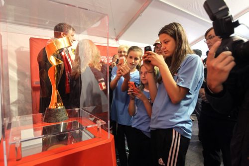 Members of the Phoenix Soccer Club, take iPhone photos of the FIFA trophy with their teammates at the first-ever glimpse unveiling this morning (Friday) that took place under the fan experience pop-up tent  in the parking lot at Polo Park Shopping Centre.   May 08, 2015 Ruth Bonneville / Winnipeg Free Press