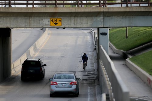 A cyclist near the underpass on Archibald, Saturday, May 9, 2015. (TREVOR HAGAN/WINNIPEG FREE PRESS)