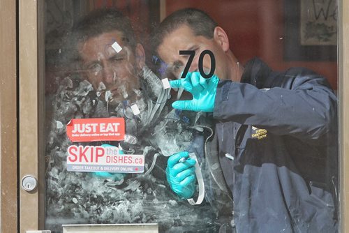 Winnipeg Police Service Officers from the forensic unit gather fingerprints from the door to Chicago Phils pizza restaurant on Donald Street Sunday morning. According to Const. Eric Hofley, two men are in stable condition after being shot around 2 a.m. on Donald Street south of Broadway.  150510 May 10, 2015 Mike Deal / Winnipeg Free Press