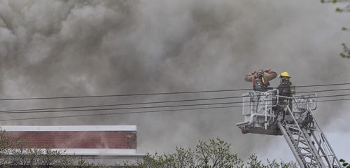 Thick black smoke pours out of a four-storey building, which is empty and undergoing renovations, at 543 Bannatyne Ave. Police have closed off streets for blocks around the fire.  150510 May 10, 2015 Mike Deal / Winnipeg Free Press