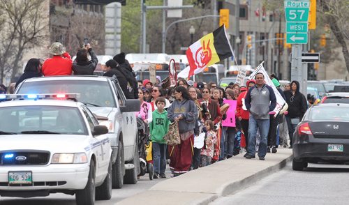 Crossing Main Street at York Avenue the Sisters in Spirit annual Mothers Day Walk honouring missing and murdered Aboriginal women started at the St-Regis Hotel (285 Smith) and ended at the Oodena Circle at The Forks. 150510 May 10, 2015 Mike Deal / Winnipeg Free Press