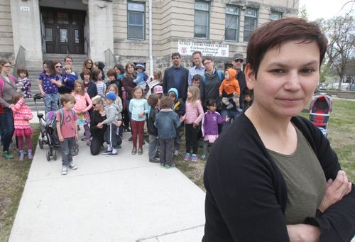 Stacy Huard chair of the Sir William Osler ( SWO) community council, left, stands with other parents and children in front of SWO school Tuesday- Recently they got word that Nursery to Grade 1 will be bused each day to another nearby school and then returned at end of day for daycare and pickup- - See Nick Martin story- May 12, 2015   (JOE BRYKSA / WINNIPEG FREE PRESS)