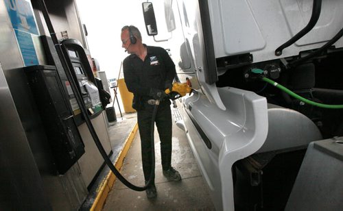 Andre LaPalme tops up the saddle tanks on his rig in Winnipeg Tuesday. He's headed to the mid west USA from Montreal. See story re: fuel prices. May 12, 2015 - (Phil Hossack / Winnipeg Free Press)