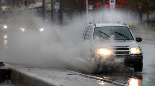 Vehicles splash through large puddles on St. James Street during the Thursday morning rain showers.  Wayne Glowacki / Winnipeg Free Press May 14 2015