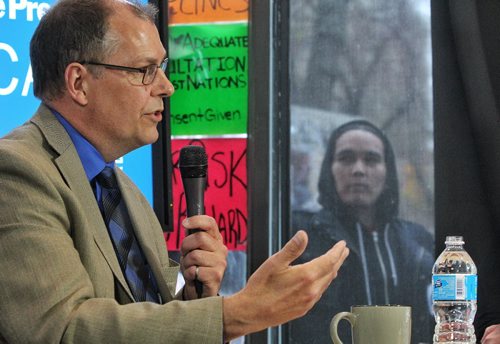 A protester holds up a sign during the Winnipeg Free Press editorial board interview with Peter Watson the NEB Chair at the Winnipeg Free Press NewsCafe.  150514 May 14, 2015 Mike Deal / Winnipeg Free Press