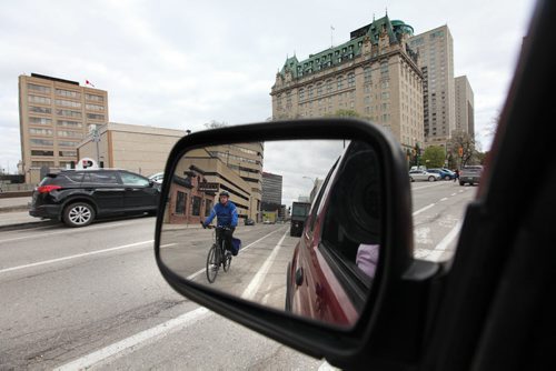 A cyclist makes their way down Garry toward Broadway Friday afternoon in the bike lane.  May 14, 2015 Ruth Bonneville / Winnipeg Free Press