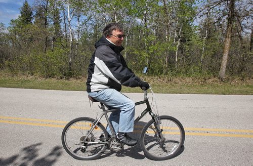 Jarvis Chubaty rides his bike Monday afternoon after spending the weekend at Birds Hill Provincial Park.  150518 May 18, 2015 Mike Deal / Winnipeg Free Press
