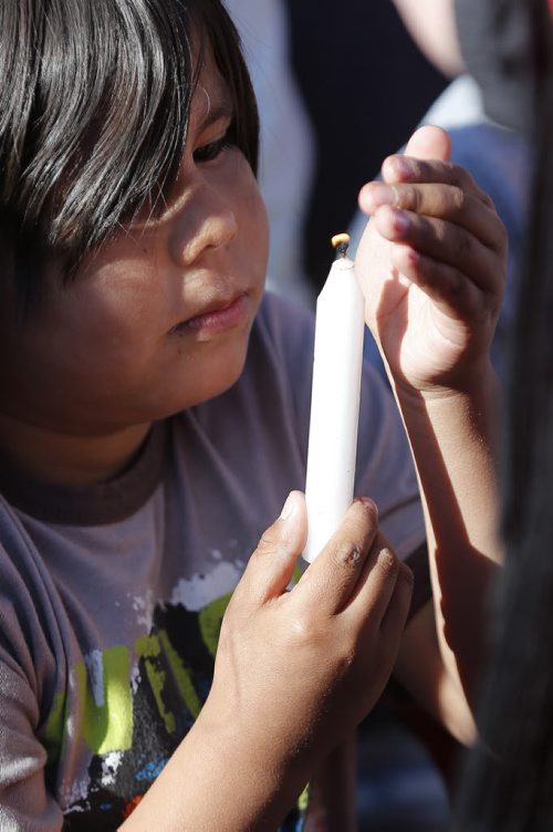 May 18, 2015 - 150518  -  A young boy protects the flame of his candle at a vigil for Teresa Robinson. On Monday, May 18, 2015 people gathered at the Oodena Circle at the Forks for a vigil for Teresa Robinson, an eleven year old who was killed on the first nation community of Garden Hill. John Woods / Winnipeg Free Press