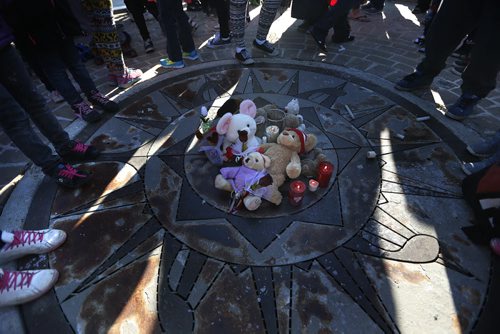 May 18, 2015 - 150518  -  Young children surround a candle and toys placed at a vigil for Teresa Robinson. On Monday, May 18, 2015 people gathered at the Oodena Circle at the Forks for a vigil for Teresa Robinson, an eleven year old who was killed on the first nation community of Garden Hill. John Woods / Winnipeg Free Press