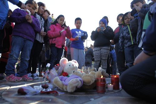 May 18, 2015 - 150518  -  Young children surround a candle and toys placed at a vigil for Teresa Robinson. On Monday, May 18, 2015 people gathered at the Oodena Circle at the Forks for a vigil for Teresa Robinson, an eleven year old who was killed on the first nation community of Garden Hill. John Woods / Winnipeg Free Press
