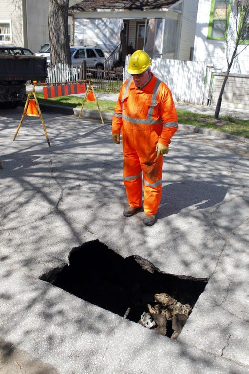 STANDUP - A substantial sink hole on Banning Street between Ellice Ave. and St. Mathews Ave. City of Winnipeg workers put up the closed road signs. Workers did not want to give their names. BORIS MINKEVICH/WINNIPEG FREE PRESS May 19, 2015 sinkhole