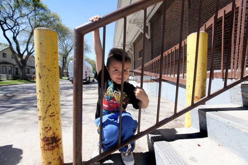 Jerimiah Spence, who is almost four, hangs off the railing at the Freight house on Ross Ave. in the Centennial Area of Winnipeg Tuesday.  See Mary Agnes story on income gap within the city. May 19, 2015 Ruth Bonneville / Winnipeg Free Press