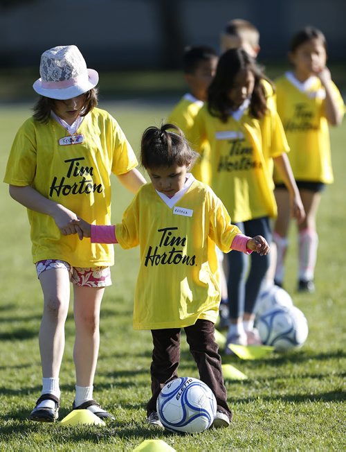 May 19, 2015 - 150519  -  Andrea Harper, 3, is helped by an older girl in a soccer program that encourages participation by inner-city girls Tuesday, May 19, 2015. John Woods / Winnipeg Free Press
