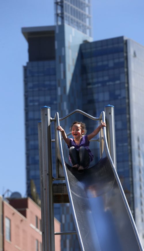 Aaliyah Lamirande-McKay,3, shows her grandmother her sliding skills in Central Park on the sunny warm Wednesday afternoon. The backdrop is the Manitoba Hydro office tower on Portage Ave.. Wayne Glowacki / Winnipeg Free Press May 20 2015