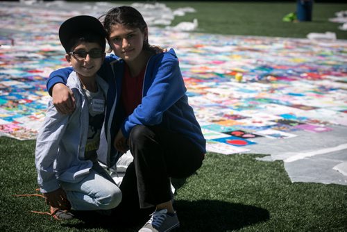 Urooba Salar, Grade 6 student at Beaumont Elementary School, poses with her brother and Grade 3 student Zaryab, in front of the panels their school that for, the Human Rights Logo - an art installation highlighting childrens human rights at Investors Group Field.  150520 - Wednesday, May 20, 2015 - (Melissa Tait / Winnipeg Free Press)
