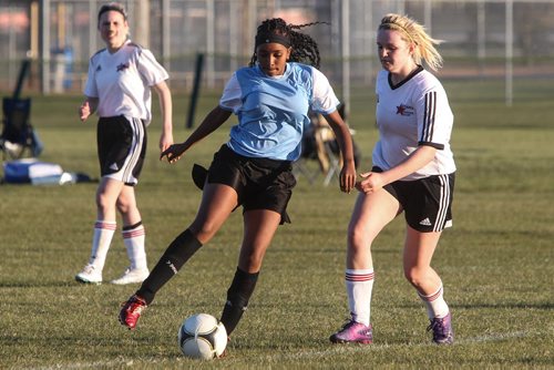 The Immigrant and Refugee Community Organization of Manitoba "IRCOM" Cobras under-16 girls soccer team playing the West St. Paul Stars U-16 team Wednesday evening. Nasra from the IRCOM Cobras moves the ball past a player with the West St. Paul Stars. 150520 - Wednesday, May 20, 2015 -  (MIKE DEAL / WINNIPEG FREE PRESS)