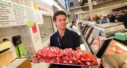 Cantor's Meat owner, ED CANTOR with a tray of pork products  at his busy meat counter at store on Logan Ave. See McNeill story.    May 21, 2015 Ruth Bonneville / Winnipeg Free Press