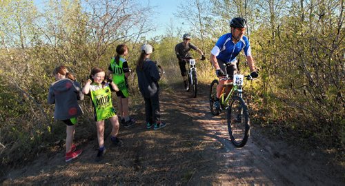 PHOTO FEATURE - Young riders watch as the adult portion of the Wednesday evening mountain bike races at Birds Hill Bird's Hill Park rounds a ridge. May 20, 2015 - (Phil Hossack / Winnipeg Free Press)