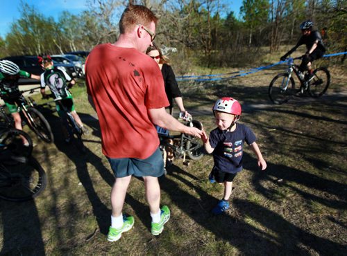 PHOTO FEATURE - Four year old Levin Broadbent gives his Dad Gavin a high five after completing two laps (2 km) in kids event of the Wednesday evening mountain bike races at Birds Hill Bird's Hill Park rounds a ridge. May 20, 2015 - (Phil Hossack / Winnipeg Free Press)