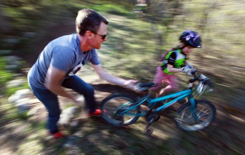 PHOTO FEATURE - Alter Ego Cycling Club President Allan Robertson supports a young rider in the "kids" portion of the Wednesday evening mountain bike races at Birds Hill Bird's Hill Park. May 20, 2015 - (Phil Hossack / Winnipeg Free Press)