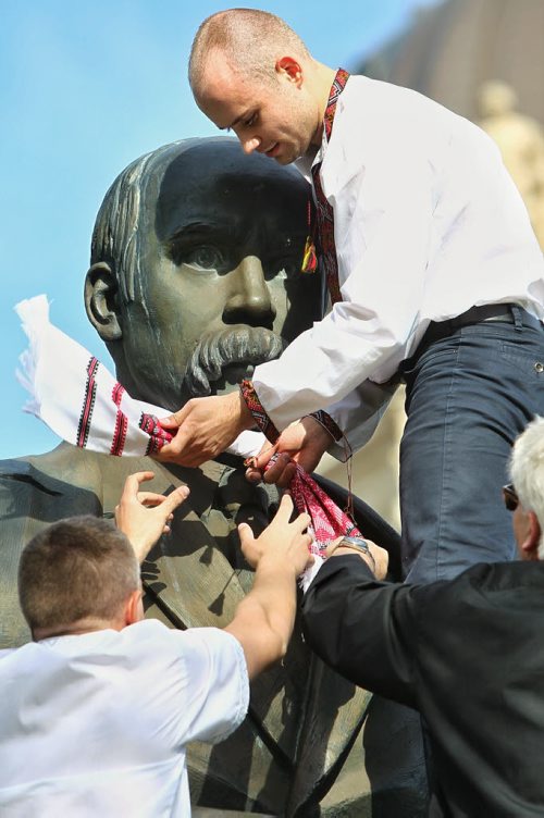 Ivan Marynovskyy (left), Oleg Azovsky (centre) and Norbert Iwan (right) put a Rushnyk or ritual cloth around the neck of the Taras Shevchenko statue on the grounds of the Manitoba Legislative building Thursday evening as they celebrate Vishivanka Day. The Winnipeg Ukrainian community is gathered at the statue before heading to The Forks and the Manitoba Theatre for Young People where the Ukrainian Kino Film Festival is taking place. Vishivanka Day is an opportunity to celebrate and promote Ukrainian culture; many approximately fifty participants wore their intricately embroidered Vishivanka shirts.  150521 May 21, 2015 Mike Deal / Winnipeg Free Press