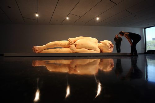 Winnipeg Art Gallery's PR coordinator Tammy Sawatzky and curator Andrew Kear (rear) take a close look at Ron Mueck's exhibit of a newborn baby  titled "A Girl",   which is startlingly large yet very life-like at the WAG Friday.  Mueck is a UK-based Austrailian artist that creates realistic yet enigmatic sculptures that portray humans at key stages in life, from birth through middle age, to death.  The works are either monumental in scale or undersized.    May 22, 2015 Ruth Bonneville / Winnipeg Free Press