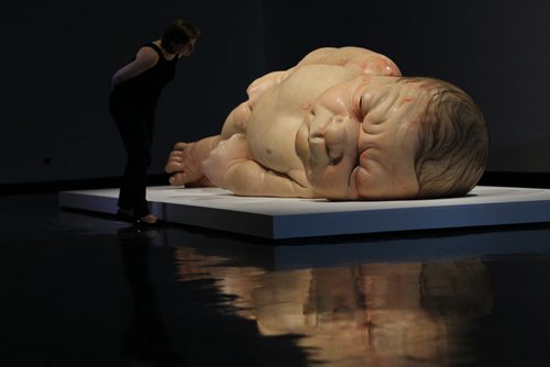 Winnipeg Art Gallery's PR Coordinator Tammy Sawatzky, takes a close look at Ron Mueck's exhibit of a newborn baby  titled "A Girl",  which is startlingly large yet very life-like at the WAG Friday.  Mueck is a UK-based Austrailian artist that creates realistic yet enigmatic sculptures that portray humans at key stages in life, from birth through middle age, to death.  The works are either monumental in scale or undersized.    May 22, 2015 Ruth Bonneville / Winnipeg Free Press