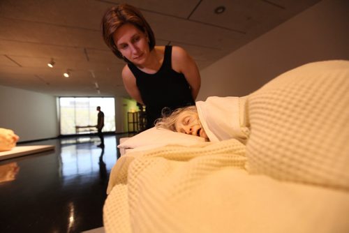 Winnipeg Art Gallery's PR coordinator Tammy Sawatzky, takes a close look at Ron Mueck's exhibit of a old woman on her death bed.  She  is small in scale yet very life-like at the WAG Friday.  Mueck is a UK-based Austrailian artist that creates realistic yet enigmatic sculptures that portray humans at key stages in life, from birth through middle age, to death.  The works are either monumental in scale or undersized.    May 22, 2015 Ruth Bonneville / Winnipeg Free Press