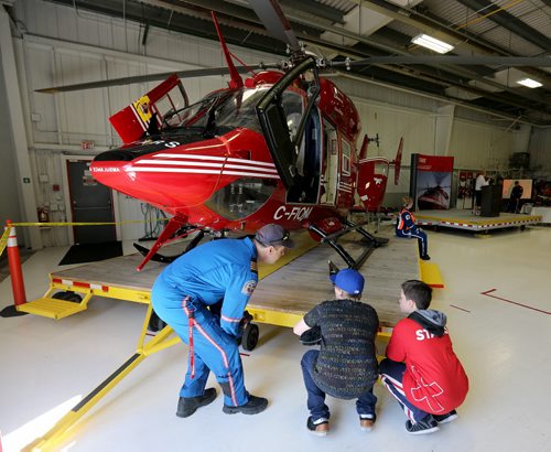 Pilot Paul Adams speaks with Shea Coughlin, 12, and Dylan Cote, 11, at the STARS hanger, Saturday, May 23, 2015. (TREVOR HAGAN/WINNIPEG FREE PRESS)