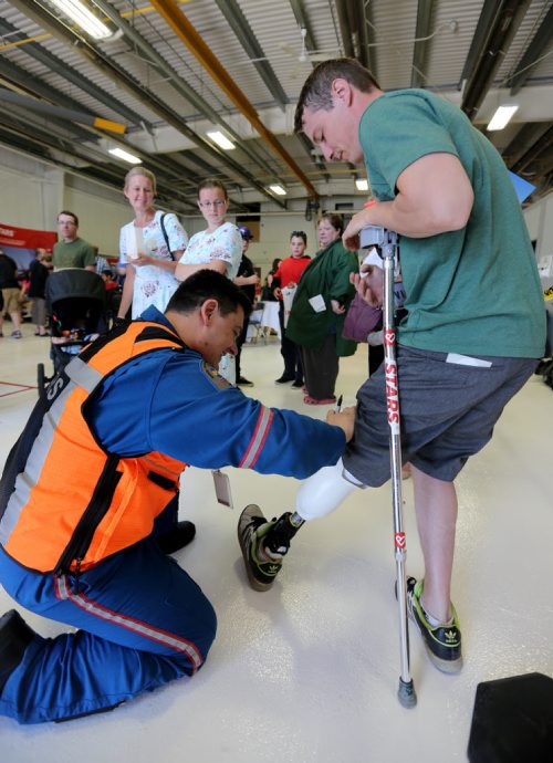 STARS air ambulance pilot Jason Graveline, signing the leg of Paul Neufeld, who lost his leg in a head on collision in November of 2012. Graveline was involved in the air call that day. Saturday, May 23, 2015. (TREVOR HAGAN/WINNIPEG FREE PRESS)