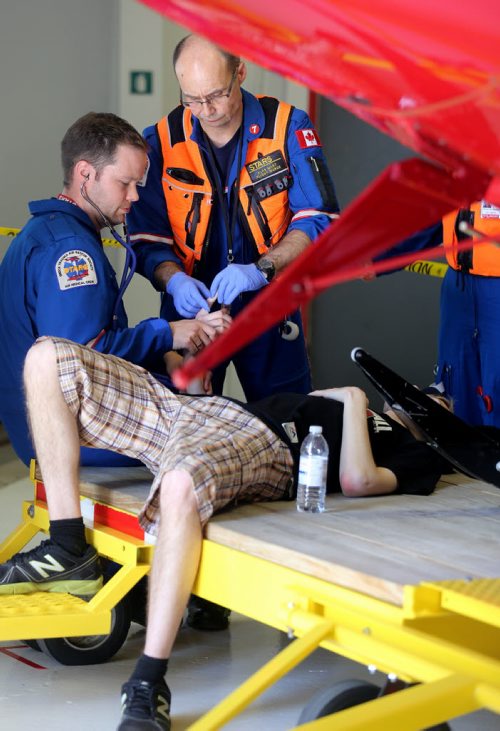 STARS medical staff treat a visitor who collapsed during an open house inside their base Saturday, May 23, 2015. (TREVOR HAGAN/WINNIPEG FREE PRESS)