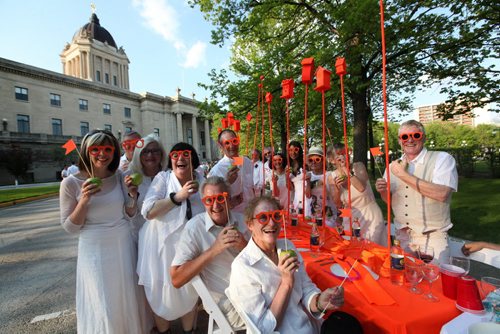 MYSTERY DINNER - Ellen MacLeod (third in from left) designed a orange neon table for her and her husband, Terry MacLeod (with CBC morning show) and their friends as they attend the Table for 1201 event at the Leg Saturday night.   May 23, 2015 Ruth Bonneville / Winnipeg Free Press