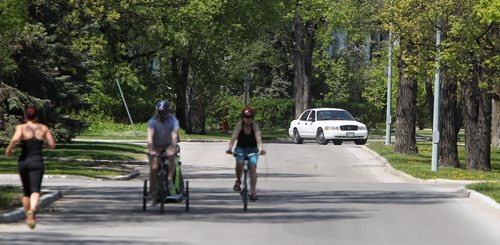 An unmarked police car makes a turn on Wellington Crescent after handing out warning tickets to motorists who were driving along Wellington Crescent Sunday which is now closed to vehicular traffic as the Sunday/Holiday Bicycle Street Closures by-law is in effect.   150524 May 24, 2015 Mike Deal / Winnipeg Free Press