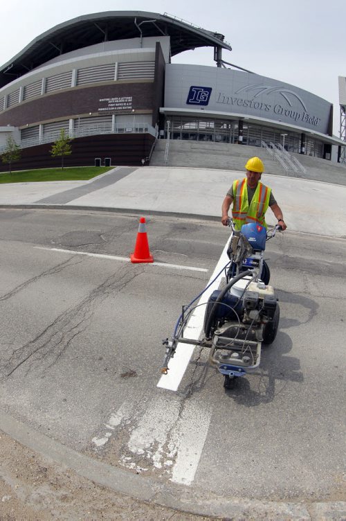 49.8 - Road lines being painted by a City of Winnipeg crews on University Crescent near the stadium. Painter is Denis Bouchard. BORIS MINKEVICH/WINNIPEG FREE PRESS May 25, 2015