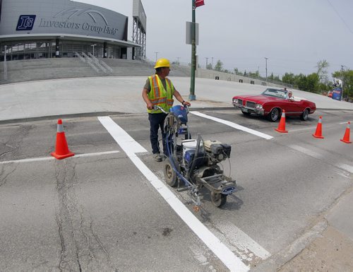 49.8 - Road lines being painted by a City of Winnipeg crews on University Crescent near the stadium. Painter is Denis Bouchard. BORIS MINKEVICH/WINNIPEG FREE PRESS May 25, 2015