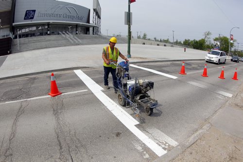 49.8 - Road lines being painted by a City of Winnipeg crews on University Crescent near the stadium. Painter is Denis Bouchard.  BORIS MINKEVICH/WINNIPEG FREE PRESS May 25, 2015