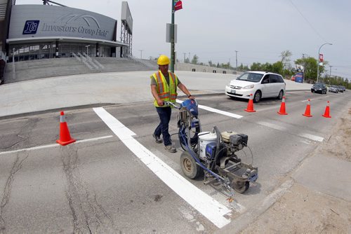 49.8 - Road lines being painted by a City of Winnipeg crews on University Crescent near the stadium. Painter is Denis Bouchard. BORIS MINKEVICH/WINNIPEG FREE PRESS May 25, 2015
