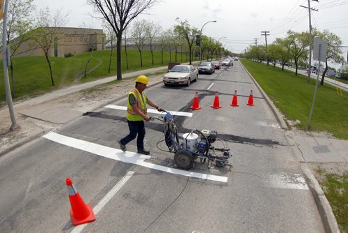 49.8 - Road lines being painted by a City of Winnipeg crews on University Crescent near the stadium. Painter is Denis Bouchard.  BORIS MINKEVICH/WINNIPEG FREE PRESS May 25, 2015