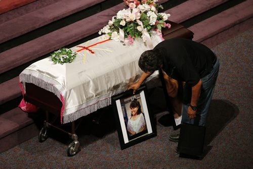 May 25, 2015 - 150525  -  A friend places a photo prior to a memorial service for Teresa Robinson. Friends and family came together to celebrate the life of Teresa Robinson at Calvary Temple Monday, May 25, 2015. John Woods / Winnipeg Free Press