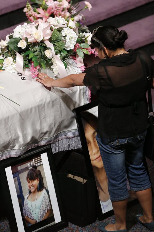 May 25, 2015 - 150525  -  A family friend places her hand on the casket of Teresa Robinson at a memorial service. Friends and family came together to celebrate the life of Teresa Robinson at Calvary Temple Monday, May 25, 2015. John Woods / Winnipeg Free Press