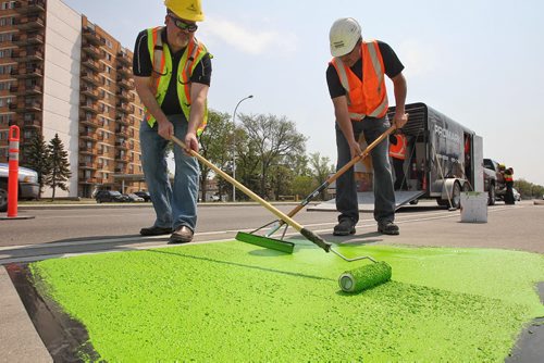 Crews from the City of Winnipeg and Promark Line Painting were on hand along Pembina Highway Tuesday afternoon for a demonstration by Ennis-Flint a traffic safety solutions company as they applied a green methyl methacrylate (MMA) or durable pavement marking to highlight the bicycle path.  150526 May 26, 2015 Mike Deal / Winnipeg Free Press