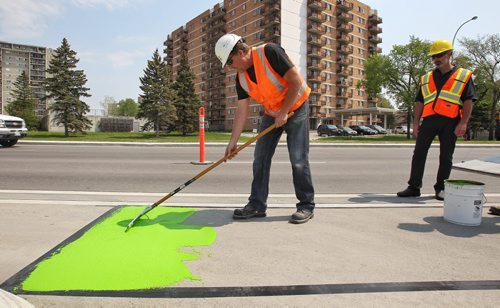 Crews from the City of Winnipeg and Promark Line Painting were on hand along Pembina Highway Tuesday afternoon for a demonstration by Ennis-Flint a traffic safety solutions company as they applied a green methyl methacrylate (MMA) or durable pavement marking to highlight the bicycle path.  150526 May 26, 2015 Mike Deal / Winnipeg Free Press