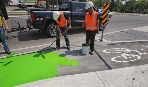 Crews from the City of Winnipeg and Promark Line Painting were on hand along Pembina Highway Tuesday afternoon for a demonstration by Ennis-Flint a traffic safety solutions company as they applied a green methyl methacrylate (MMA) or durable pavement marking to highlight the bicycle path.  150526 May 26, 2015 Mike Deal / Winnipeg Free Press